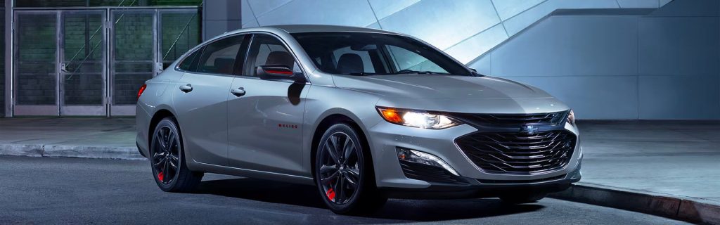 2025 Chevy Malibu looking sophisticated parked in front of a building at night