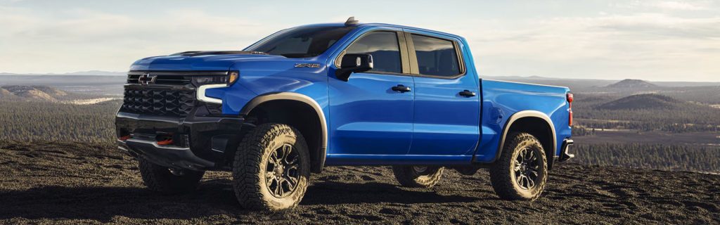 2026 Chevrolet Silverado full-size pickup truck displayed in an off-road setting, highlighting powerful performance, advanced trailering technology, and durable capability.